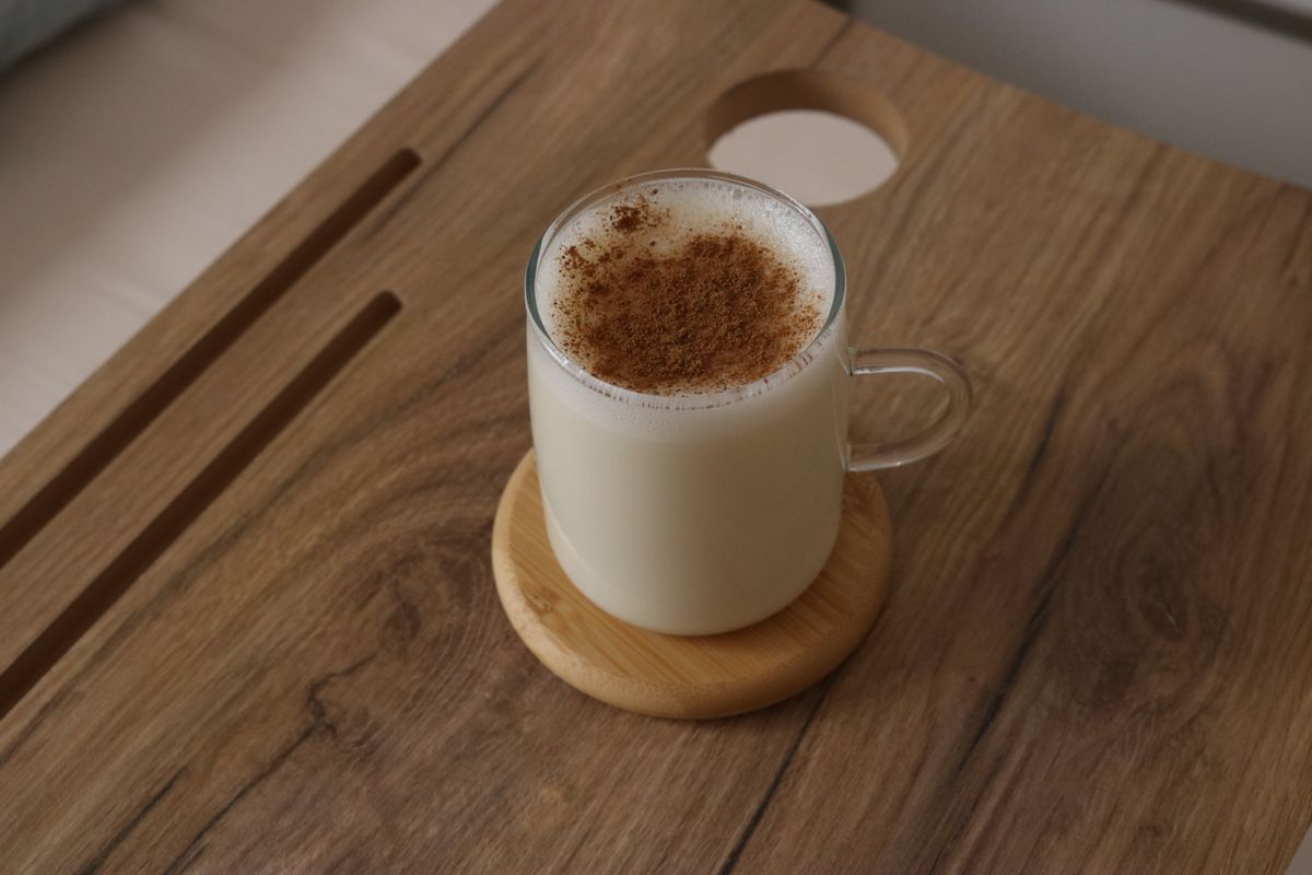 玻璃杯裝著溫熱乳白的甘酒，表面撒了香料，是被稱為喝的點滴的發酵米飲