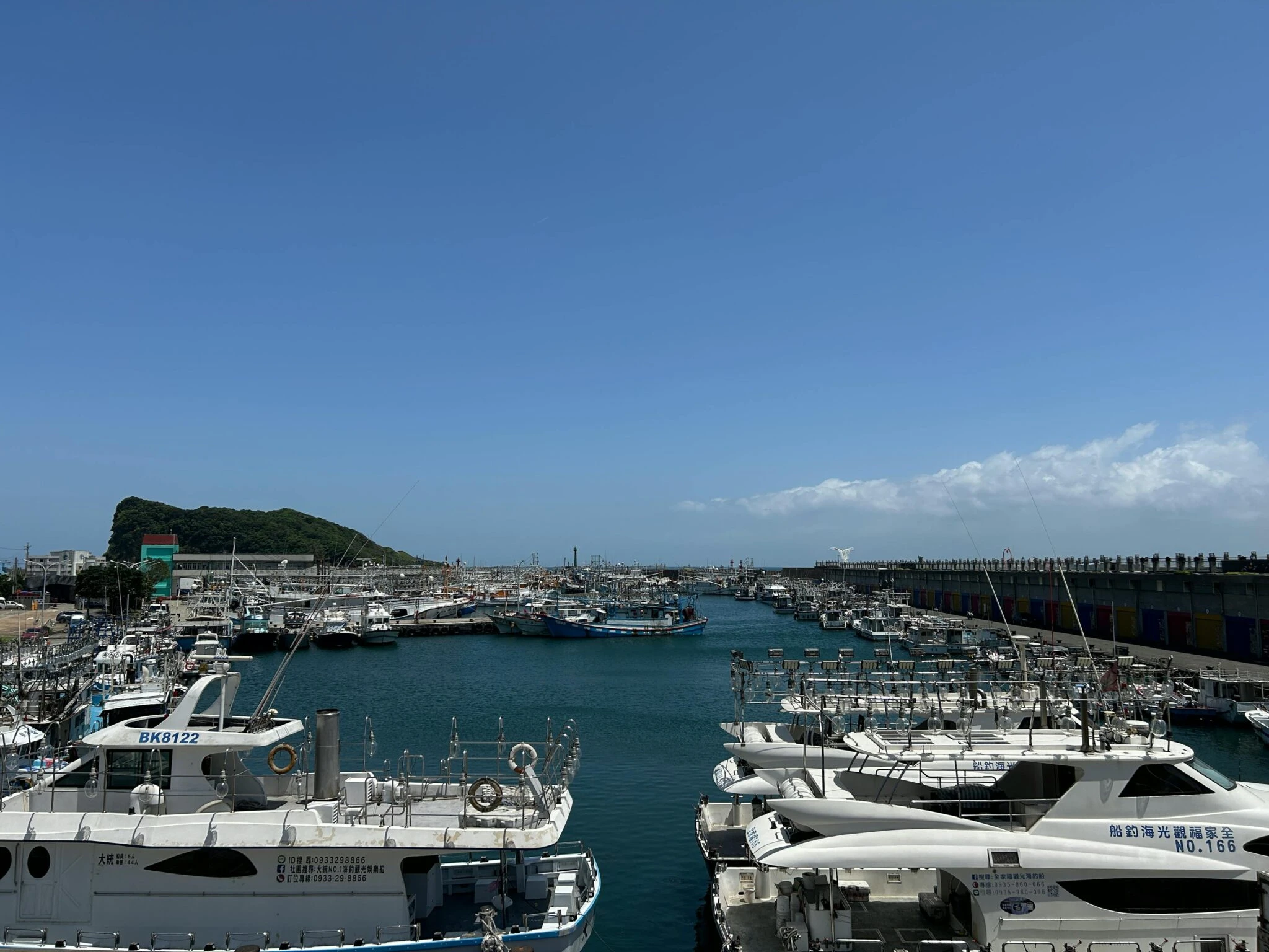 夏日陽光下台灣漁港停泊的船隻與藍天空，台灣海洋漁業意象