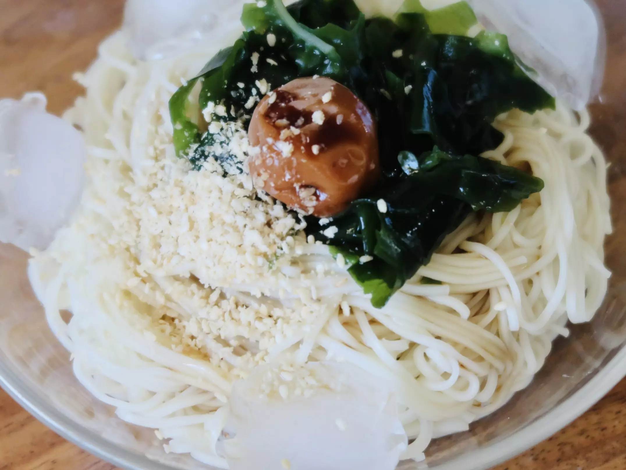 細麵冷麵俯拍,放著海帶芽、梅干並撒上芝麻