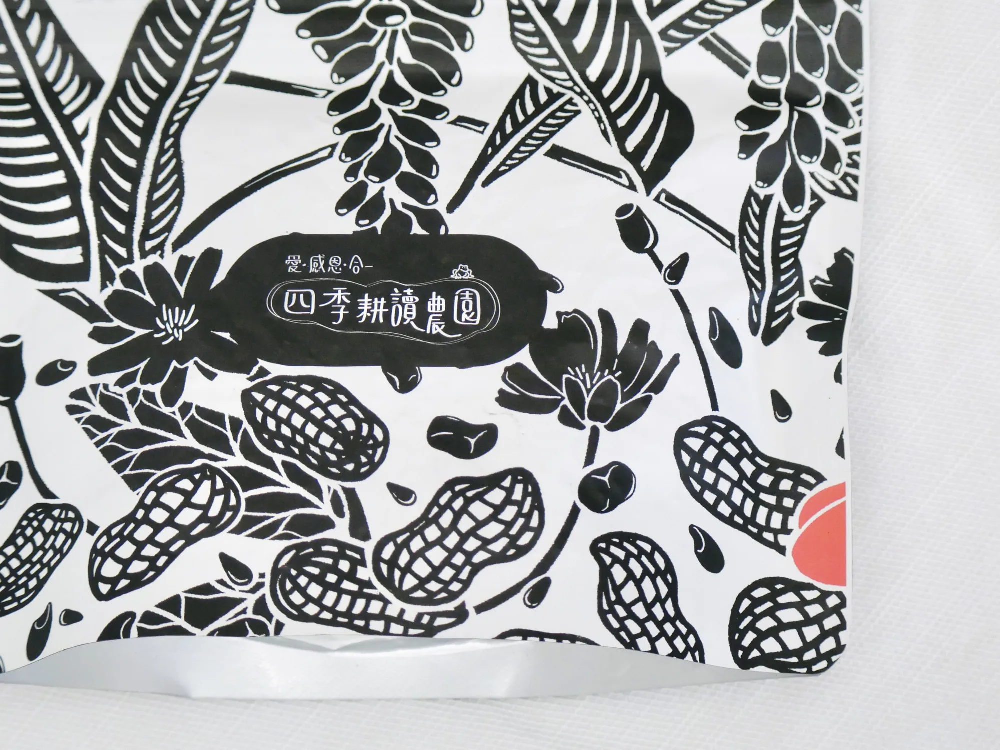 四季耕讀農園包裝袋上的黑白版畫，畫著花生、豆子與花
