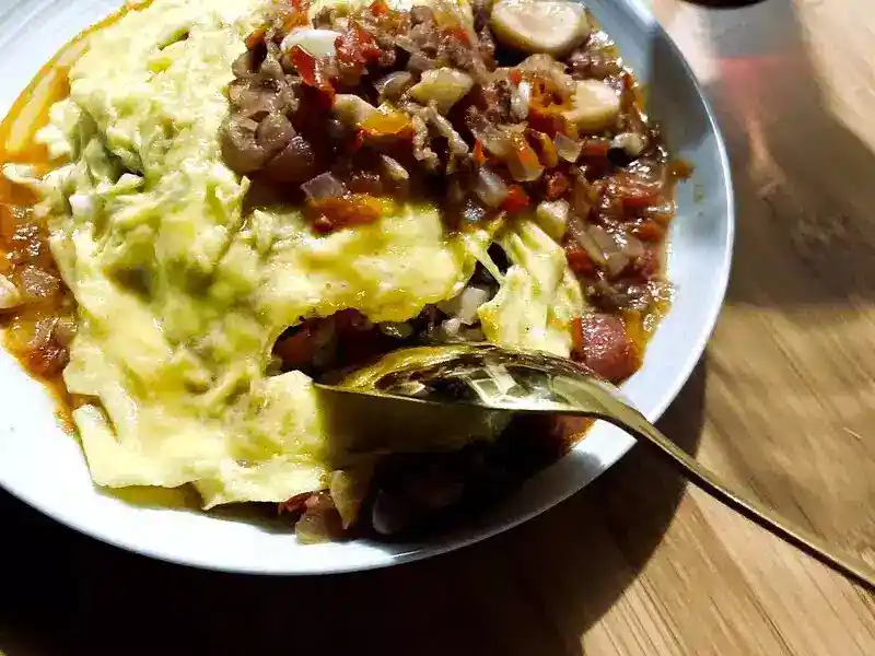 日式嫩滑蛋包飯成品，滑蛋蓋在番茄炒飯上淋醬汁