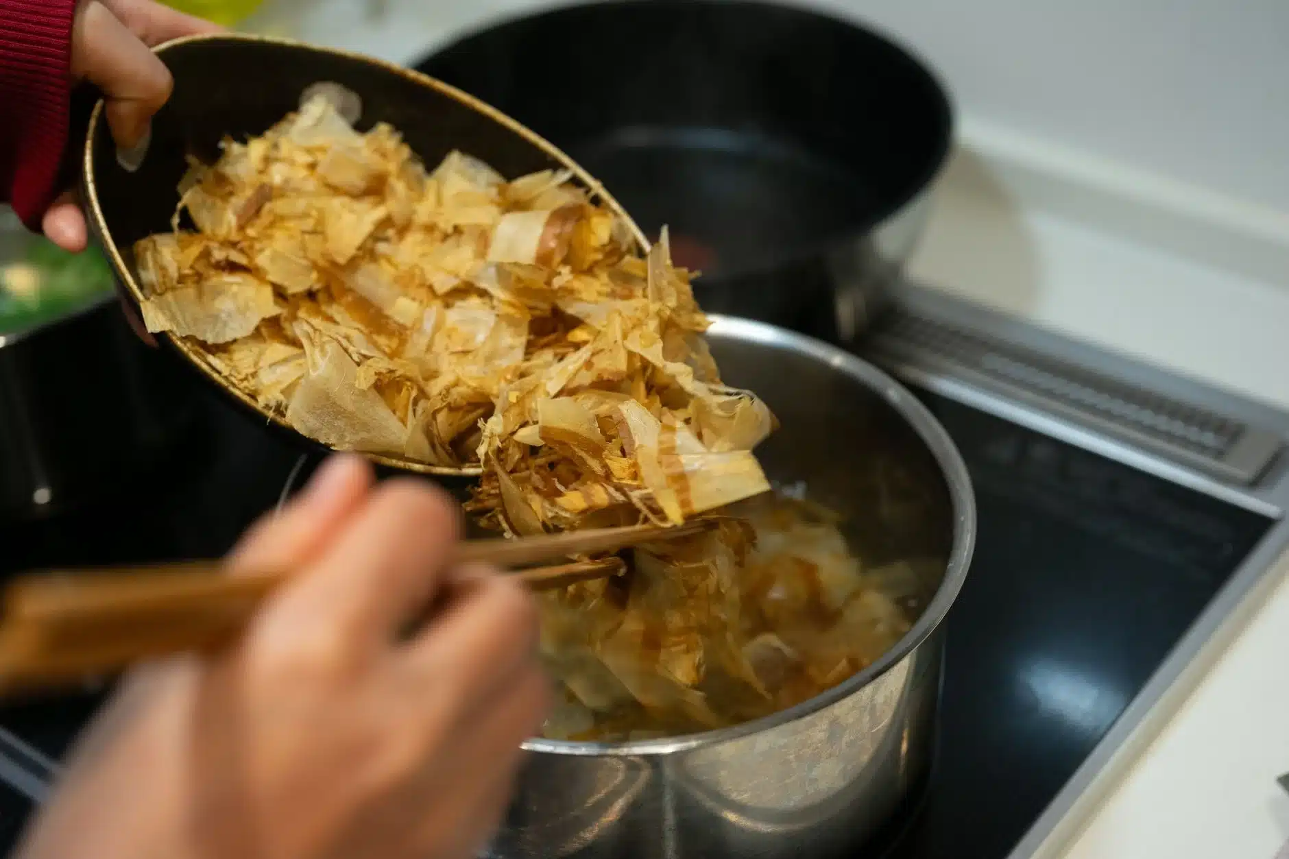 鍋中熬煮日式高湯並加入柴魚片，昆布高湯是日式料理鮮味的基礎