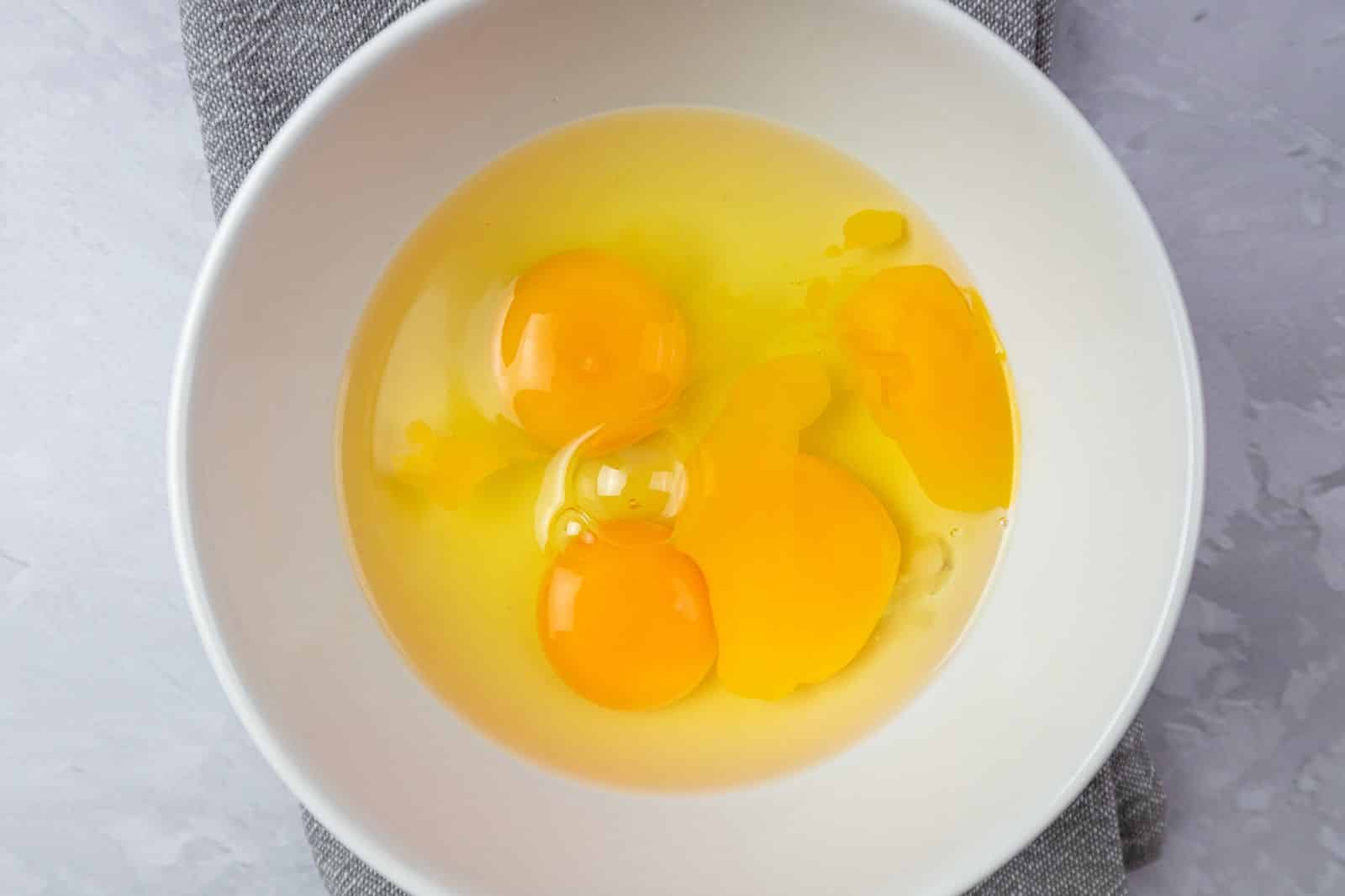白碗中打入的雞蛋，是製作滑嫩蒸蛋、調出蛋水比例的第一步