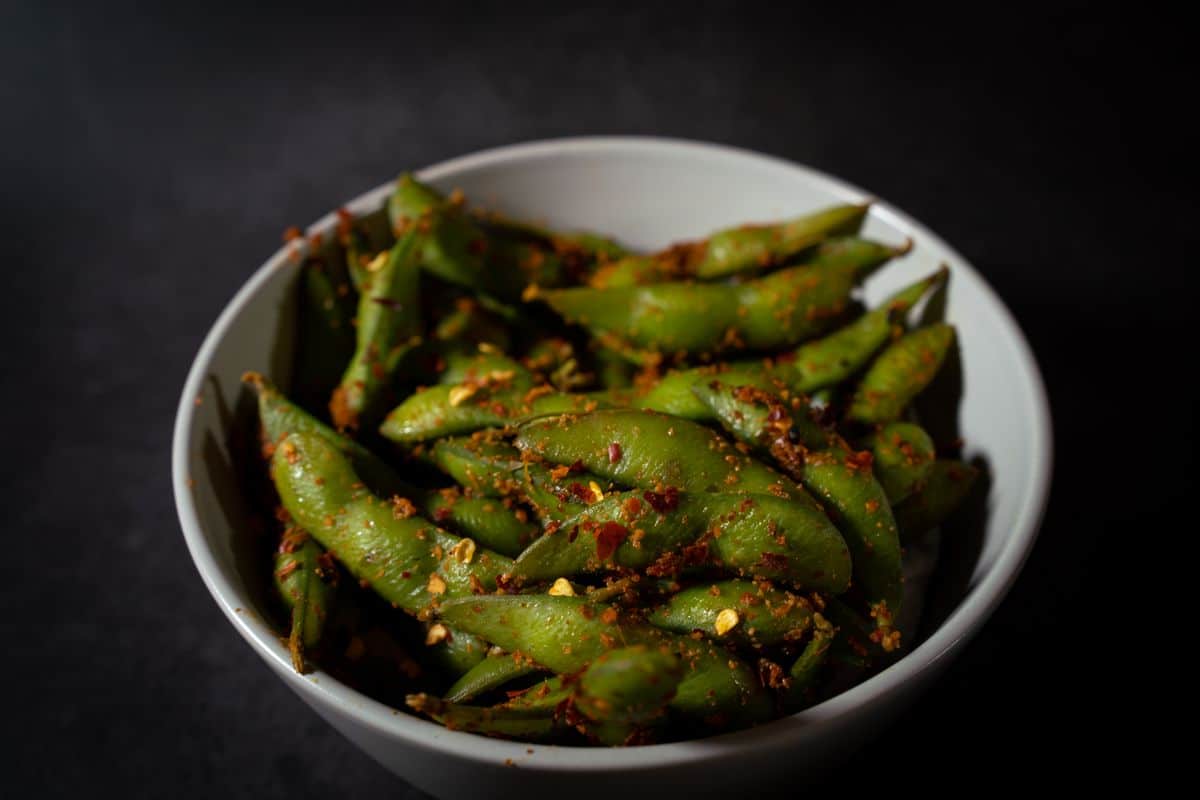 一盤拌了辣椒香料的毛豆，毛豆仁可以蒜炒、辣炒、涼拌多種家常料理