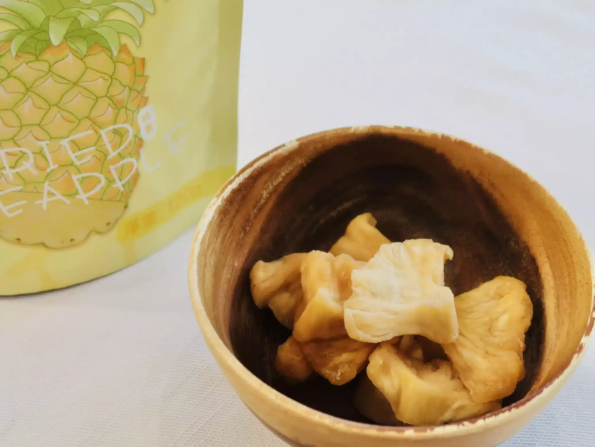 木碗裝著鳳梨乾,後面是永禎鳳梨乾袋子
