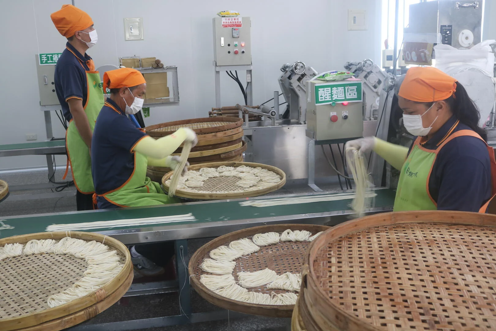 鹽水意麵工坊製麵室醒麵區,工作人員把麵條攤到竹篩上