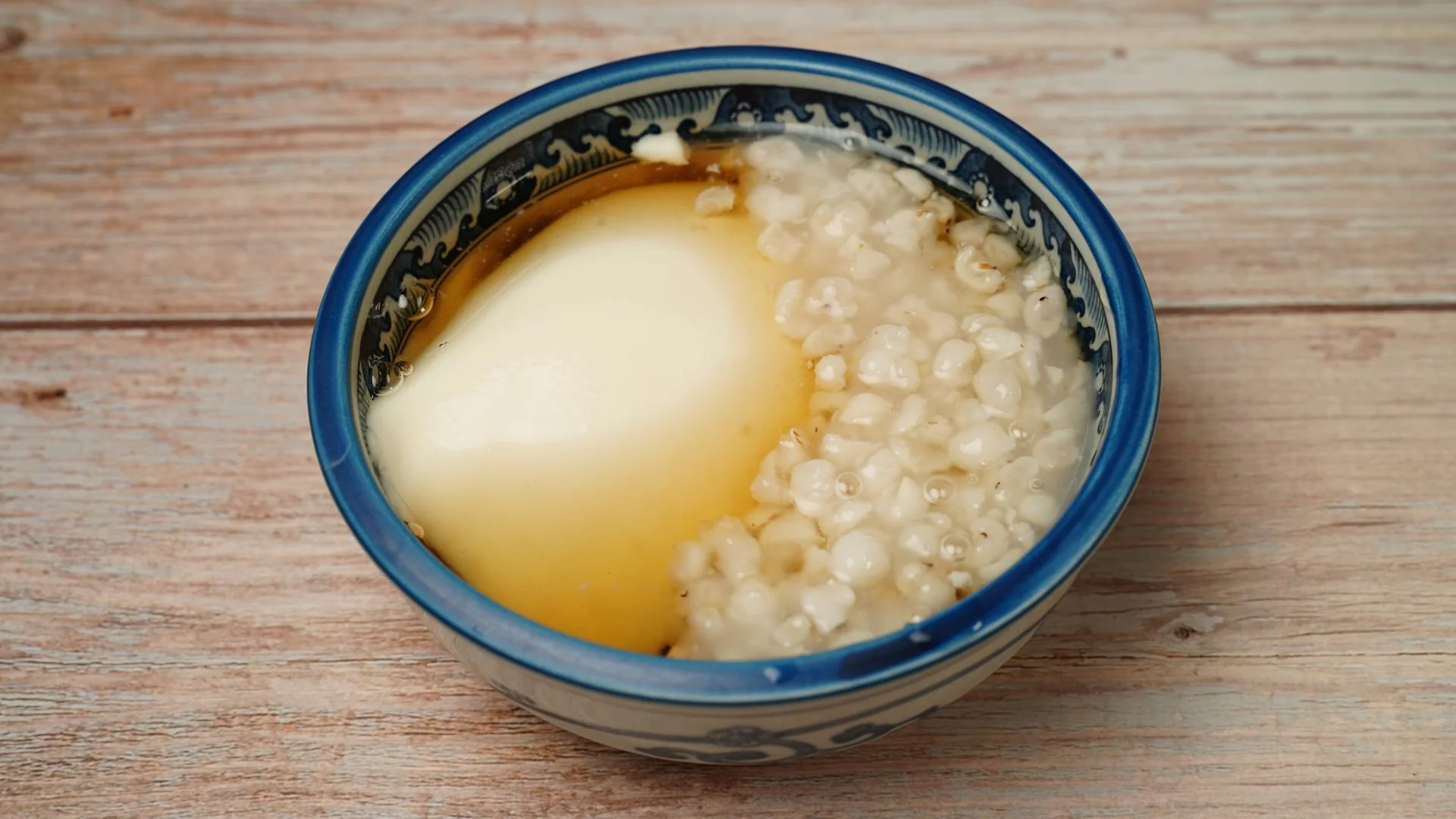 藍白瓷碗裝著加了穀粒的甜湯，冷熱皆宜