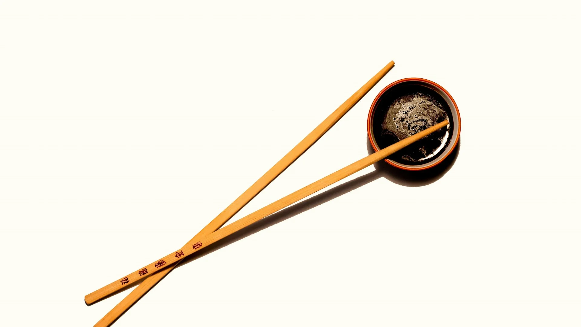 白底桌面上的醬油碟與木筷，醬油是滷肉最主要的味道來源