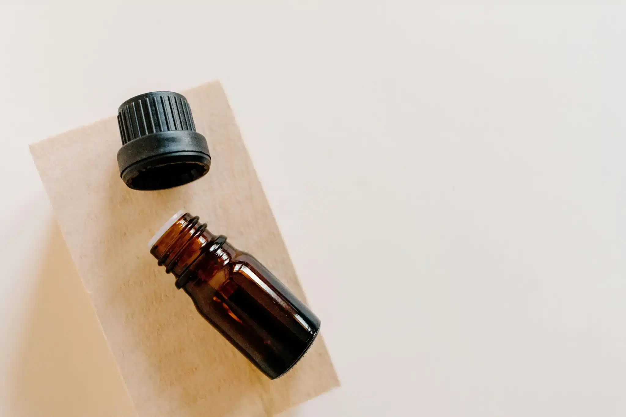 高角度拍攝打開的棕色玻璃精油瓶，代表商業精製蓖麻油的瓶裝型態