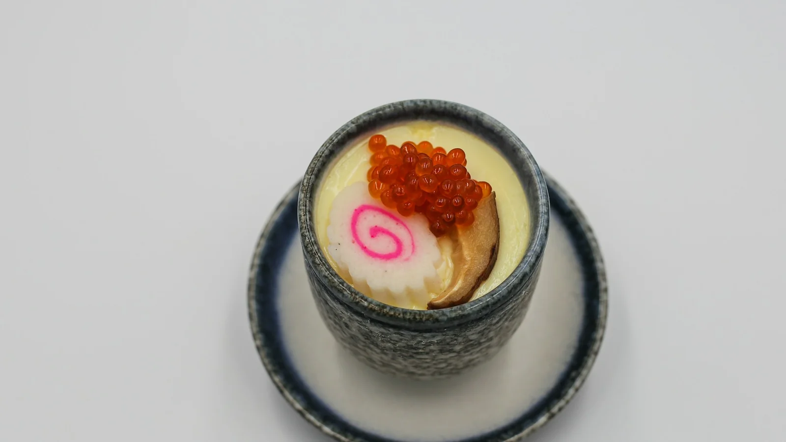 一碗蒸好的茶碗蒸,上面放著鮭魚卵和魚板