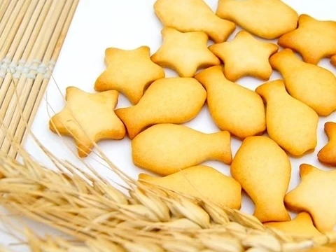 星星和小魚造型的乳酪餅乾,旁邊放著麥穗和竹簾