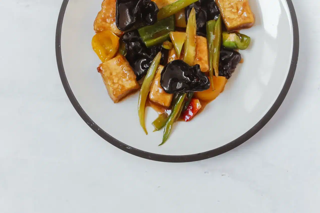 白盤裝著豆瓣醬拌炒的豆腐與蔬菜，先炒香豆瓣再下料風味更好