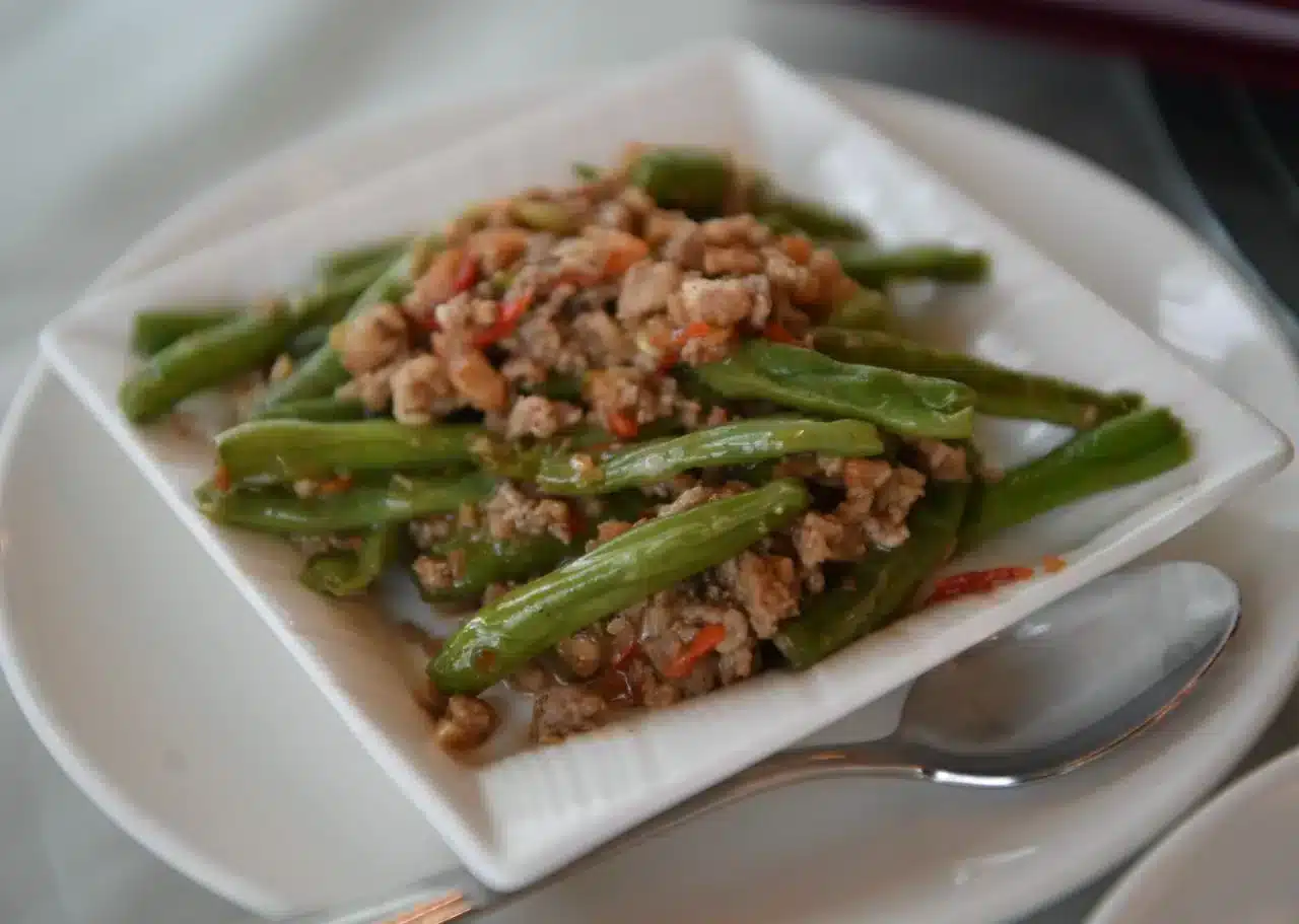 白盤裝著炒四季豆肉末的家常菜，大多數家常菜冰好都能安心隔餐吃