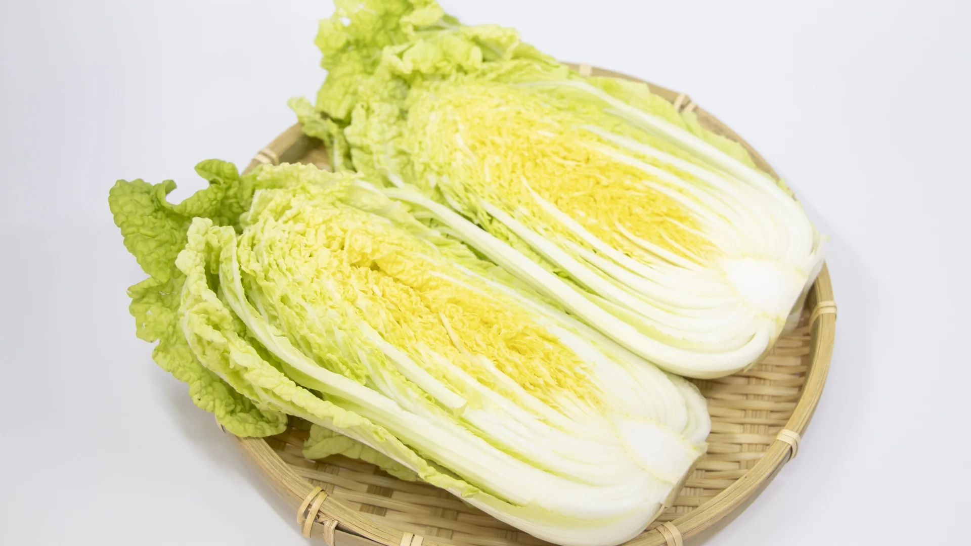 竹篩上剖半的黃心結球白菜