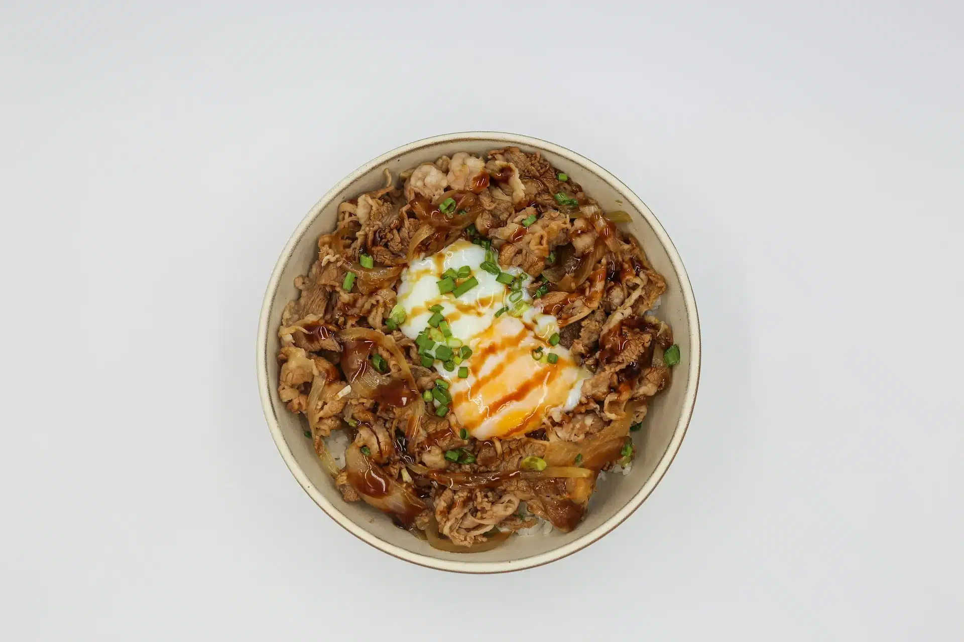 親子丼成品，滑嫩半熟蛋裹著雞肉與洋蔥淋在白飯上，撒上蔥花
