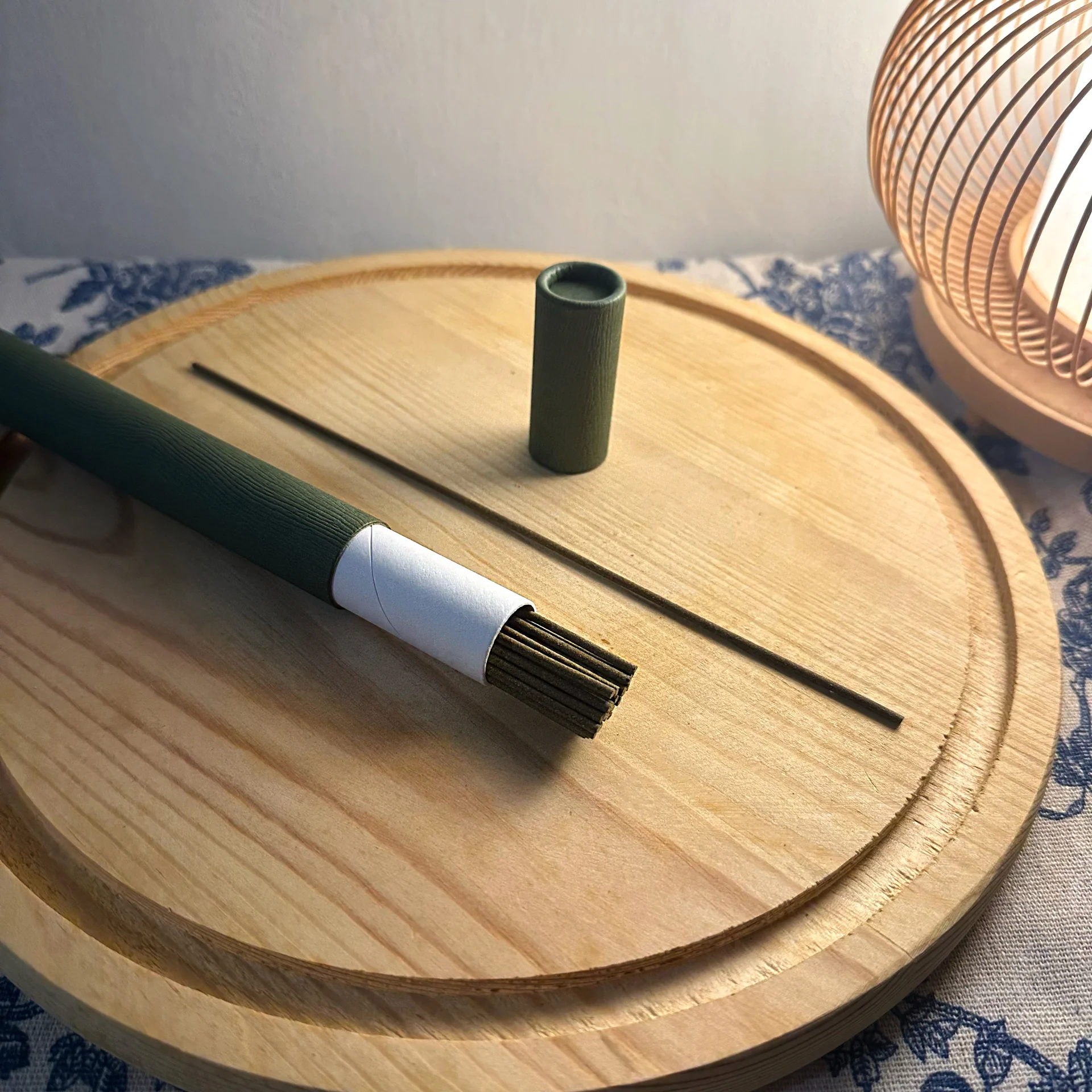 peacefy 艾草線香綠色紙筒打開，一束線香放在木托盤上
