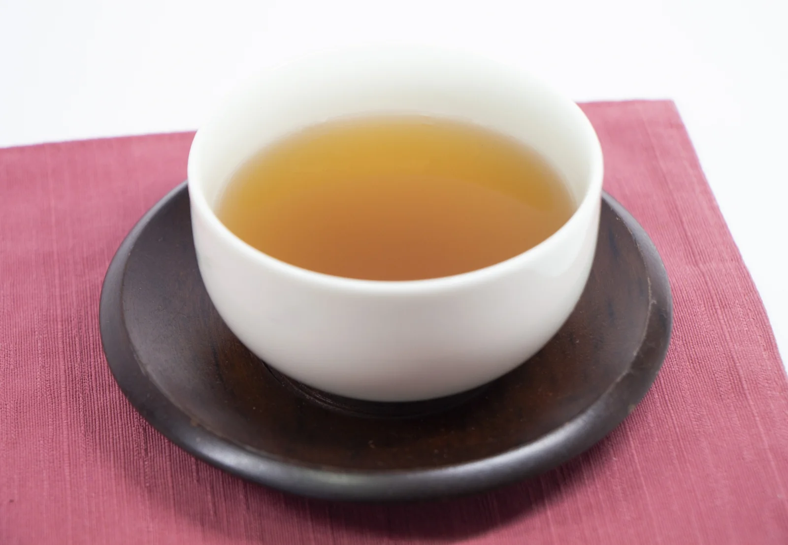 一杯溫熱的紅豆水（紅豆茶），紅褐澄清、不加糖，是只取紅豆清液的飲品