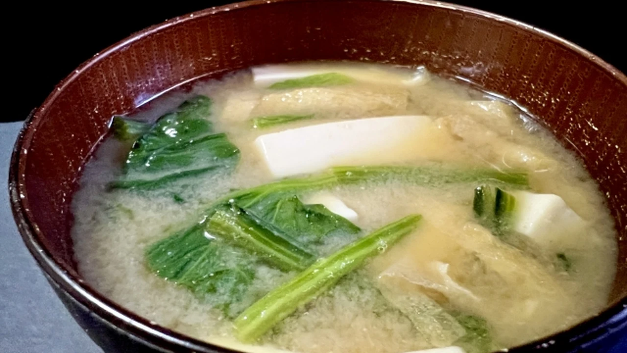 陶碗裡的菠菜豆腐湯，看得到菠菜的葉片與葉梗、切片的豆腐和油豆腐皮