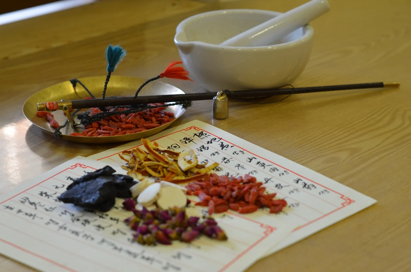 桌上鋪著中藥行常見的藥膳乾貨與研磨缽，四神湯就是用這類藥膳食材燉煮