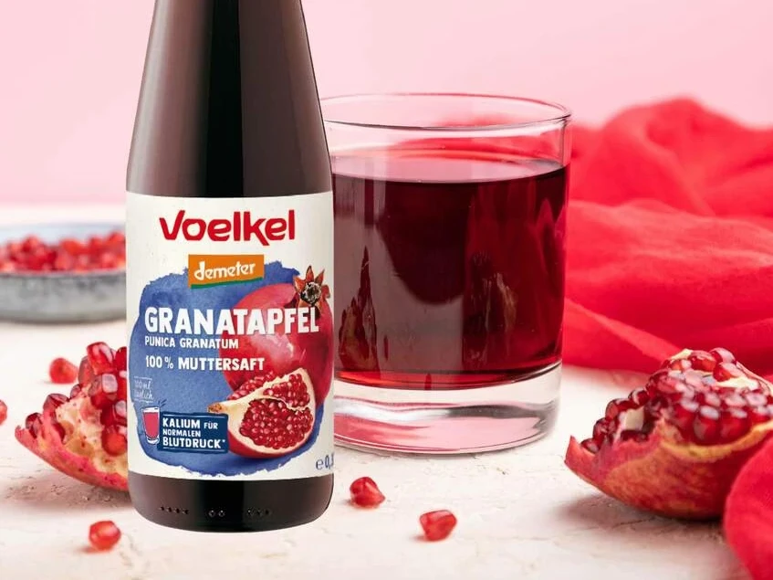 Voelkel 石榴原汁瓶身與倒入玻璃杯的深紅果汁主視覺