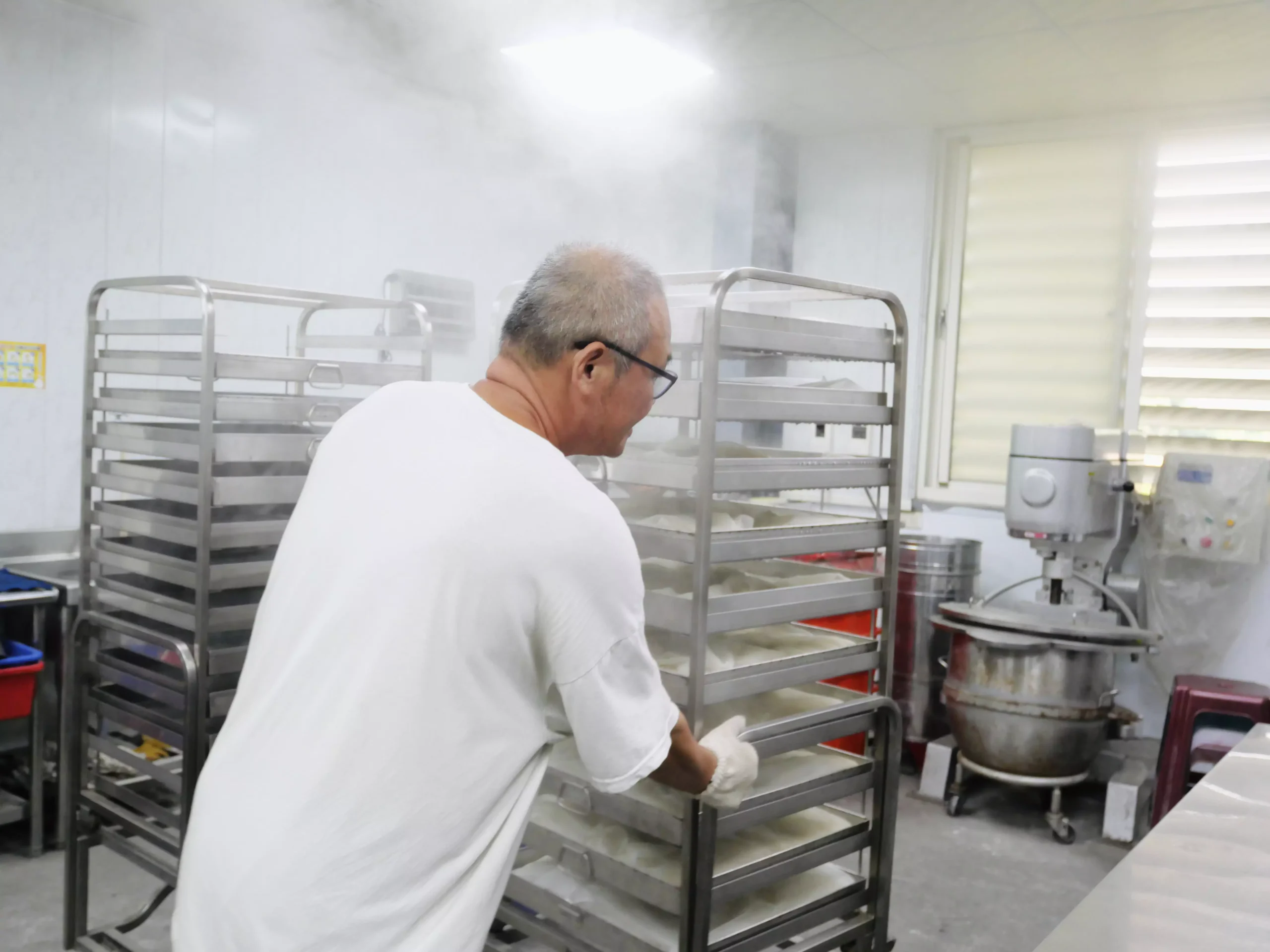 四季耕讀農園的慶豪在製麴室裡捧著一盤剛培養好的米麴