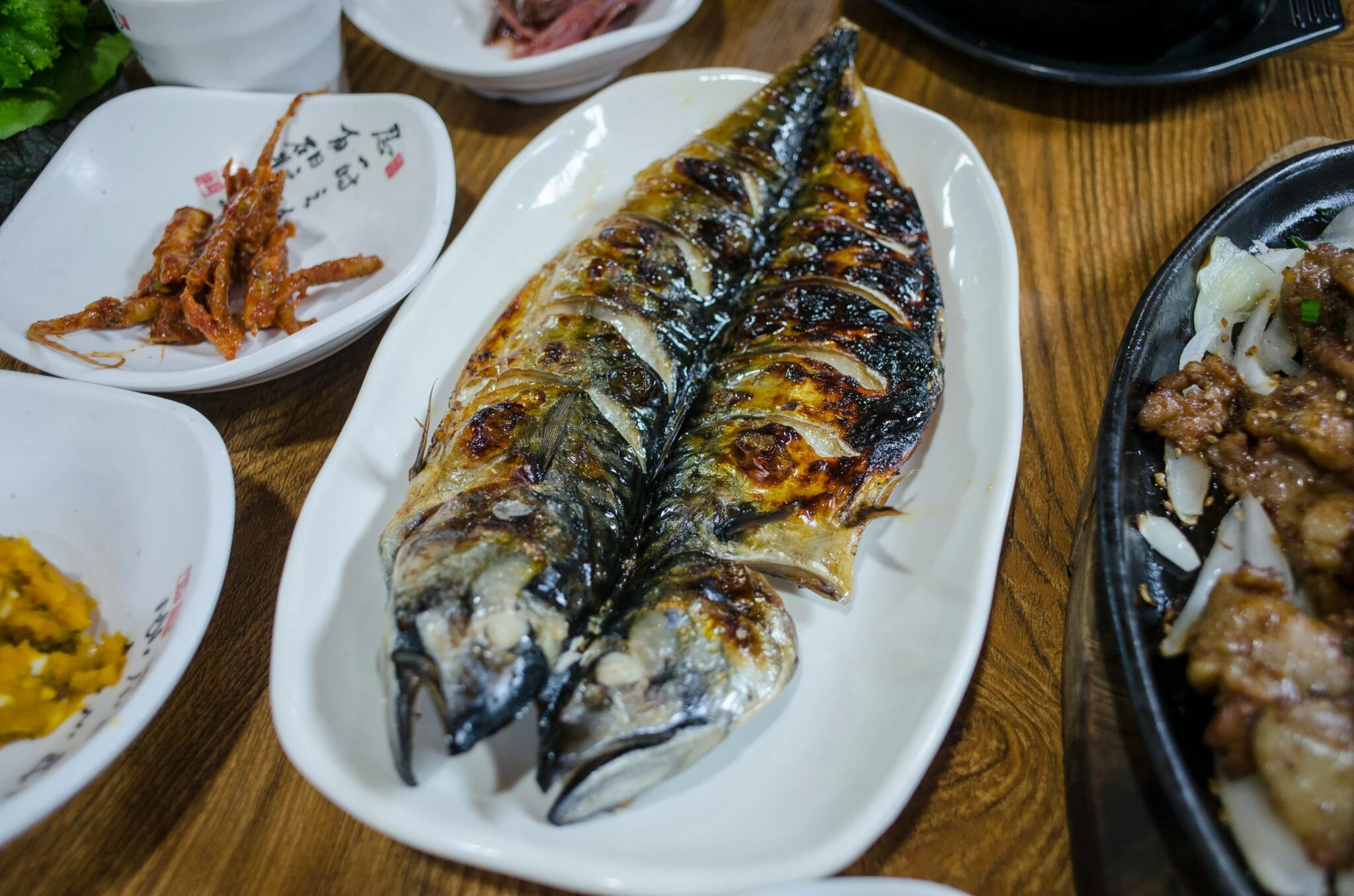 烤鯖魚裝以白盤隨以韓式側菜,omega3 魚類來源代表